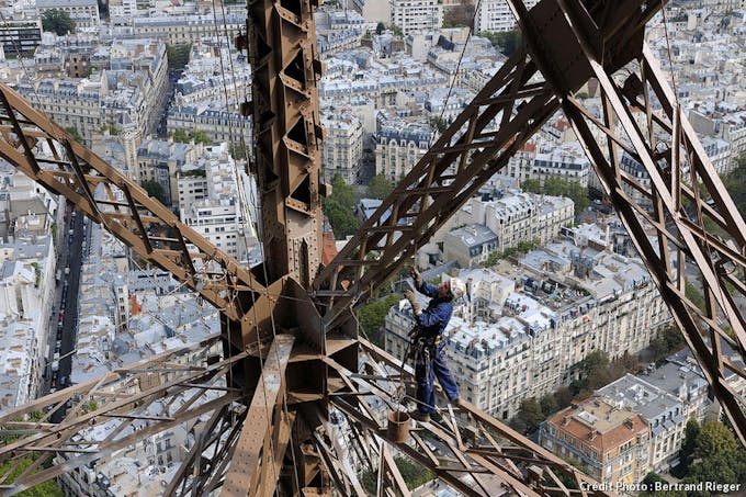 Un peintre travaille sur la tour Eiffel