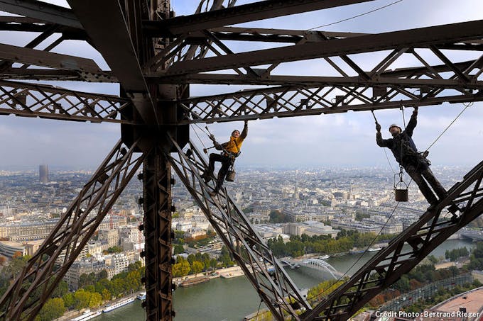 Vue imprenable sur Paris pour un peintre qui travaille sur la tour Eiffel 