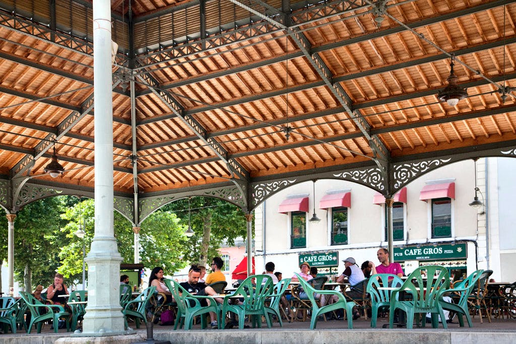 Une terrasse de café sous la halle aux grains à Foix.