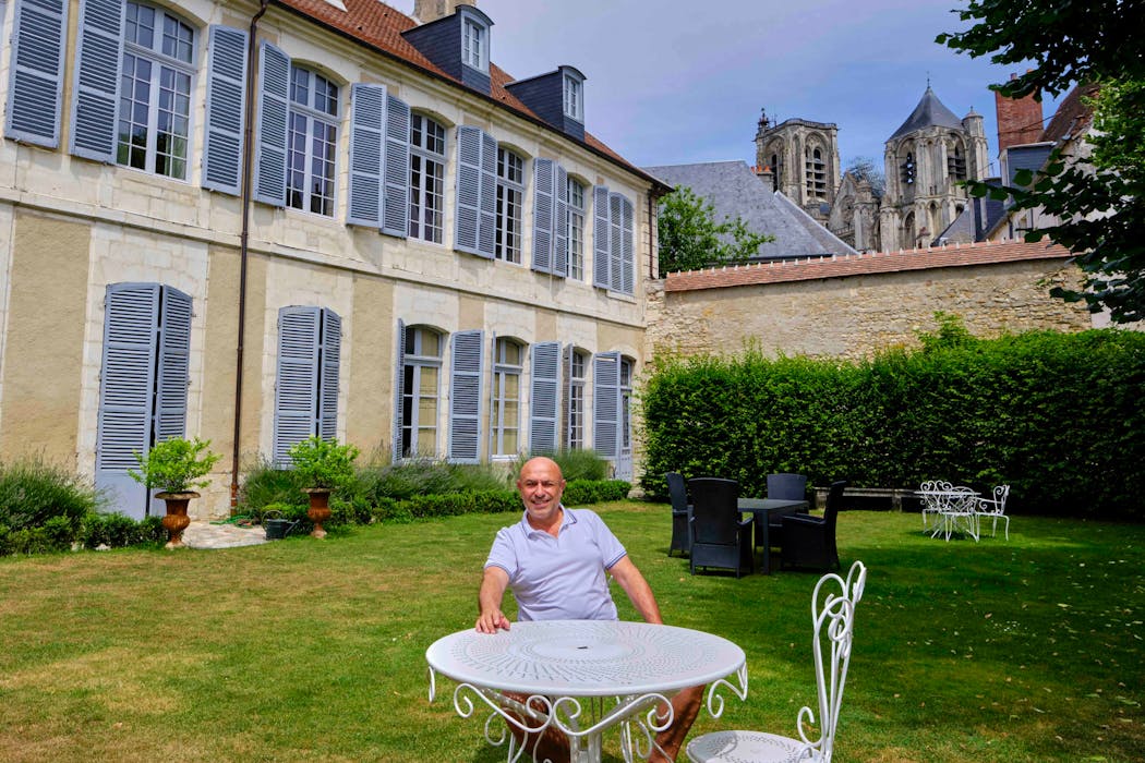 Bruno Lageline, assis devant sa propriété, un hôtel particulier à l'histoire extraordinaire,