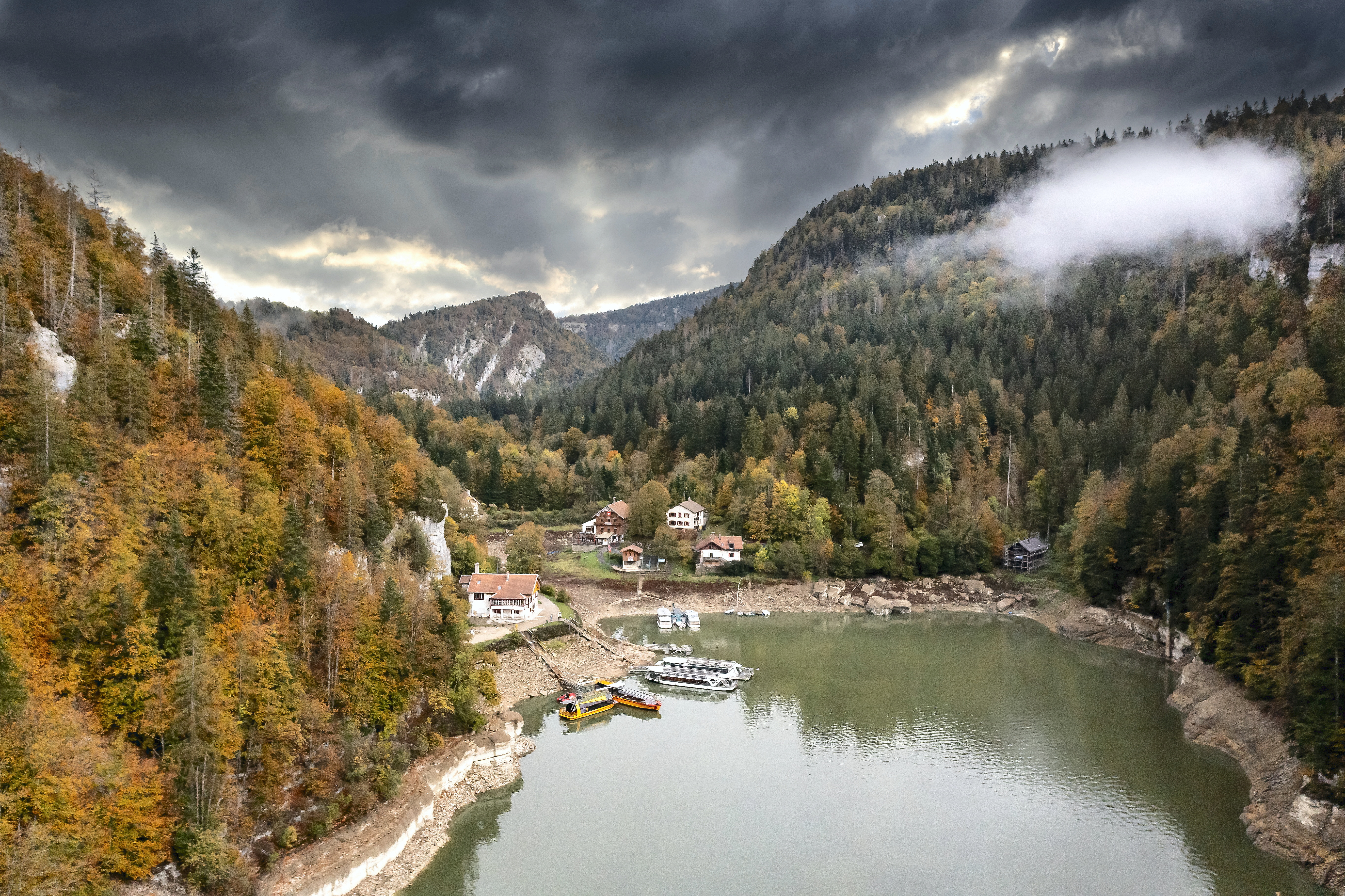 Le troisième bassin du Saut du Doubs, vu du lac des Brenets, ou lac de Chaillexon, d’une superficie de 80 hectares, avec les embarcadères des bateaux. Les trois bassins du Doubs, classés Grand Site National, sont encastrés au pied d’impres- sionnantes falaises de 40 mètres de haut.