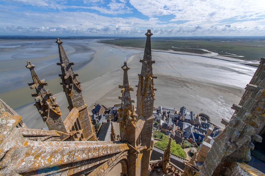 Vue depuis le sommet du Mont-Saint-Michel avec ses flèches et la baie à marée basse