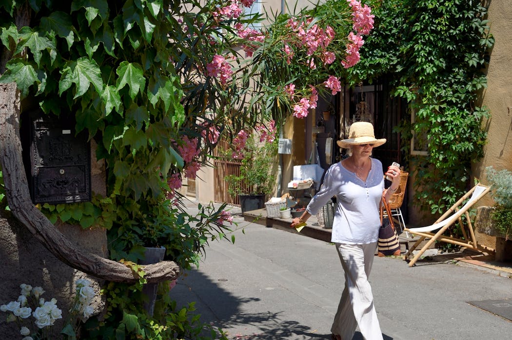 Une passante se promène dans une artère de Lourmarin dans le Vaucluse