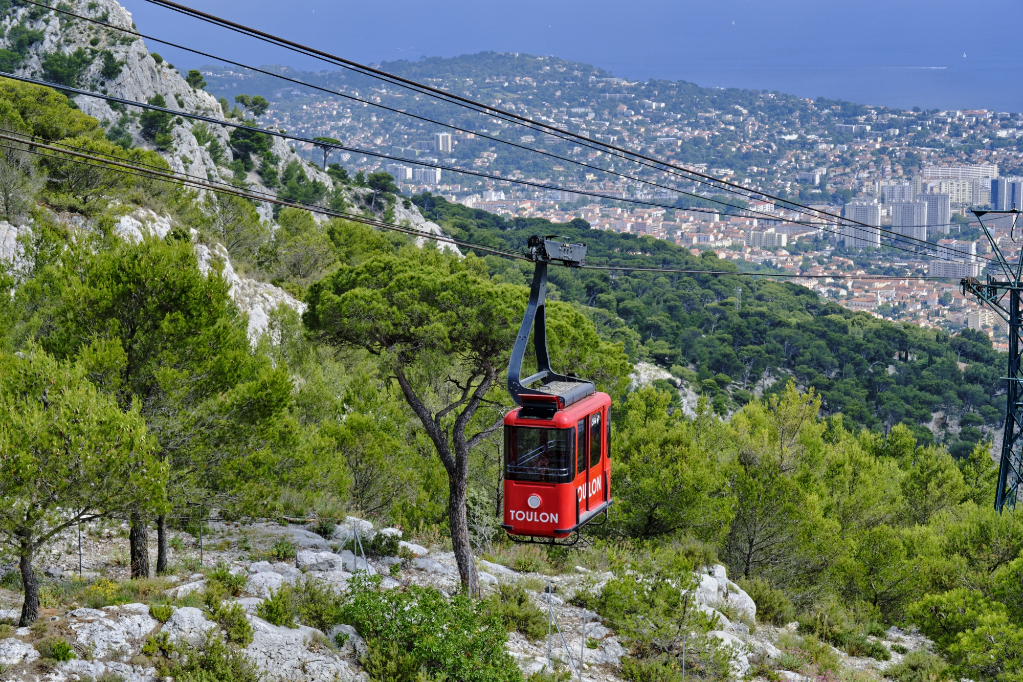 Inauguré en 1959, le téléphérique du Mont-Faron est 100 % électrique. Il est reconnaissable à ses jolies cabines rouges au look rétro.