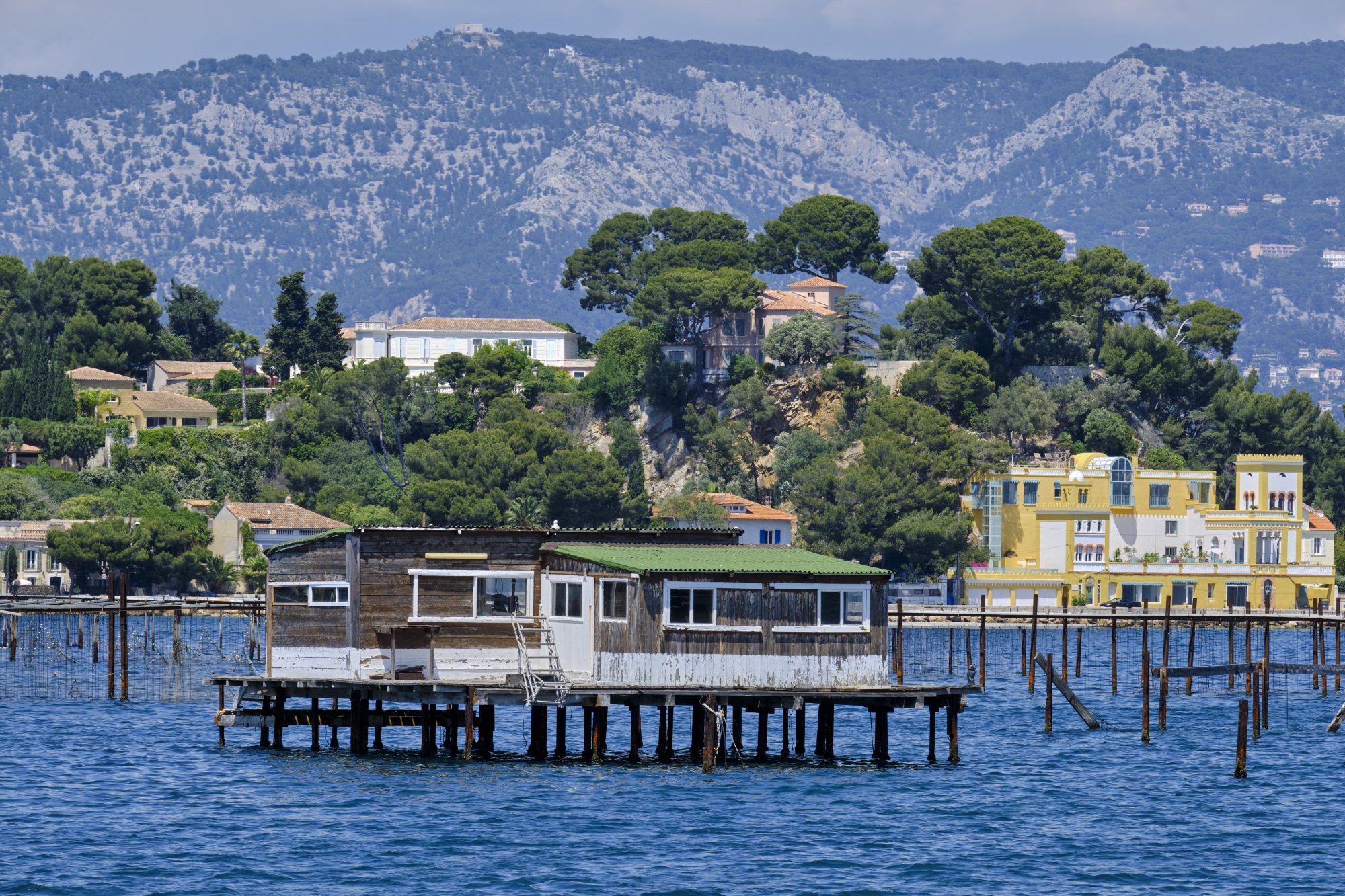 La traversée passe par le quartier résidentiel de Tamaris, au sud de La Seyne-sur-Mer, où d’anciennes cabanes sur pilotis de mytiliculteurs voisinent les villas cossues de la corniche Michel-Pacha.