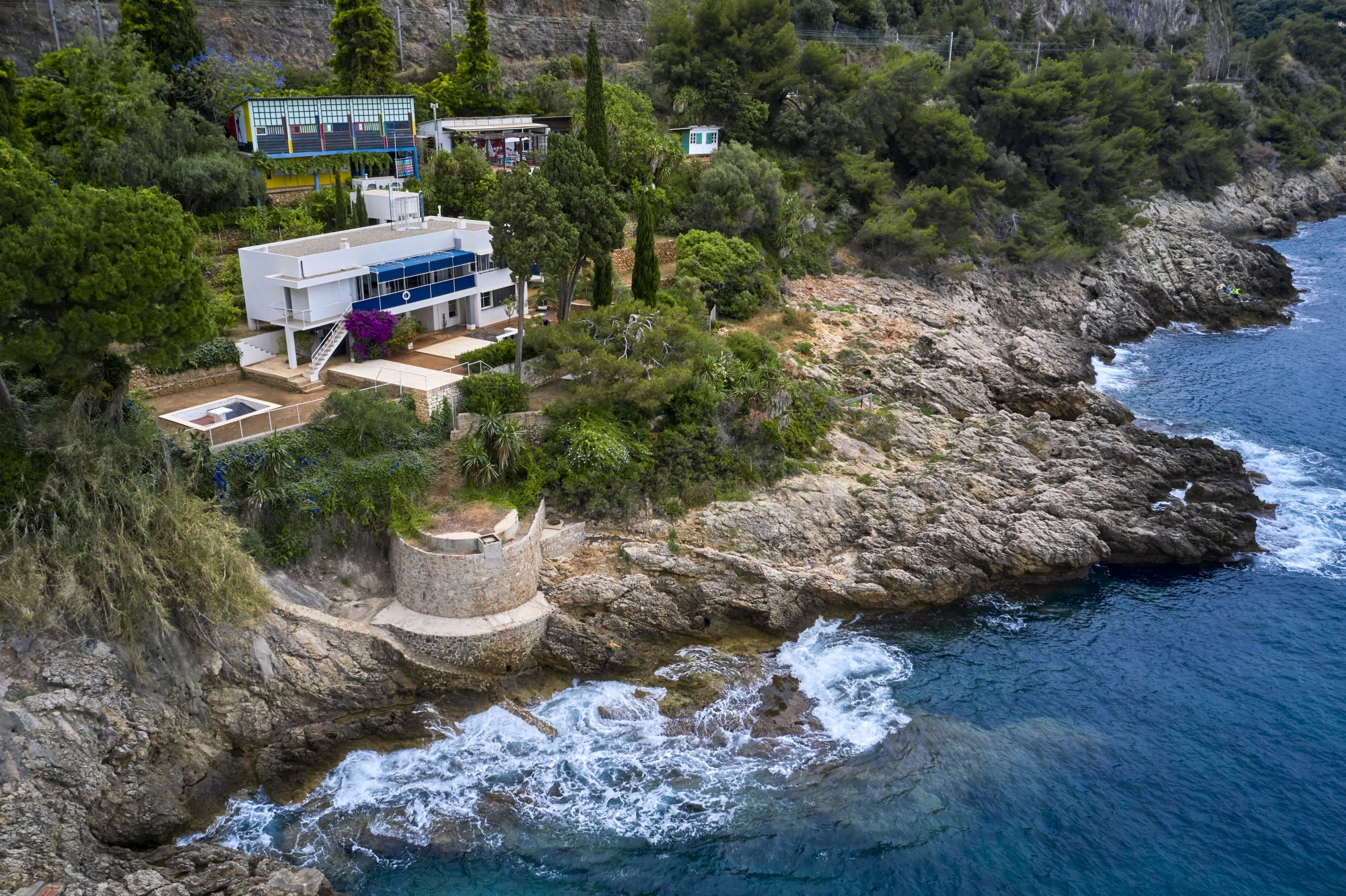 Bâches bleues et bouées blanches, structure sur pilotis et grand toit-terrasse… la villa E-1027 a des airs de paquebot qui se fond discrètement dans le décor. Un parti pris architectural à la fois sophistiqué et épuré voulu par la designeuse Eileen Gray et l’architecte Jean Badovici, concepteurs des lieux.